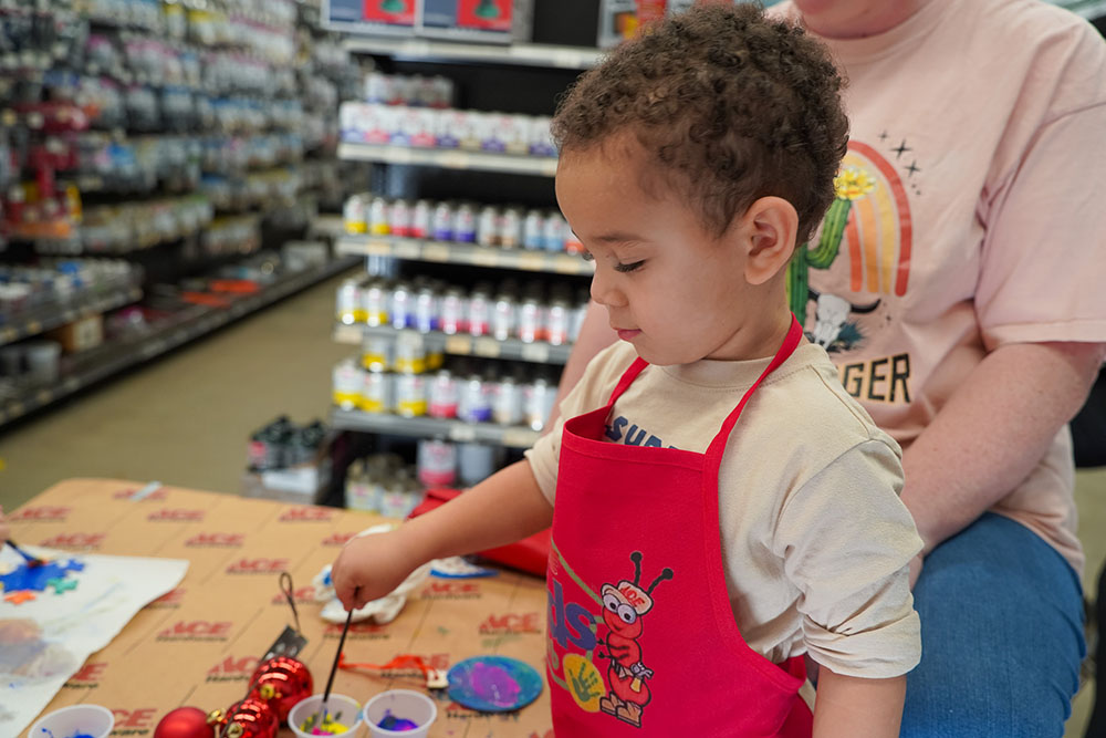 A young ornament painter at the holiday Kids Club event.