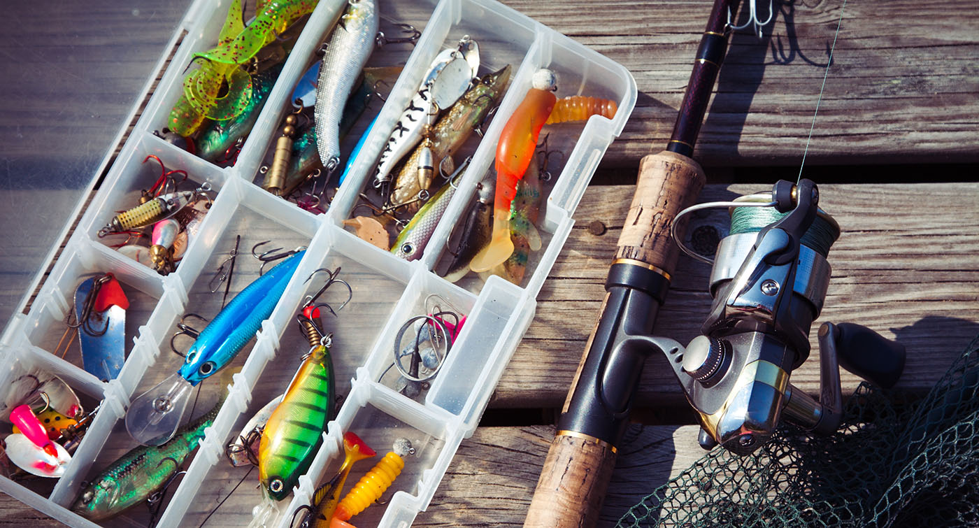 Fishing tackle and rod on a wood table.